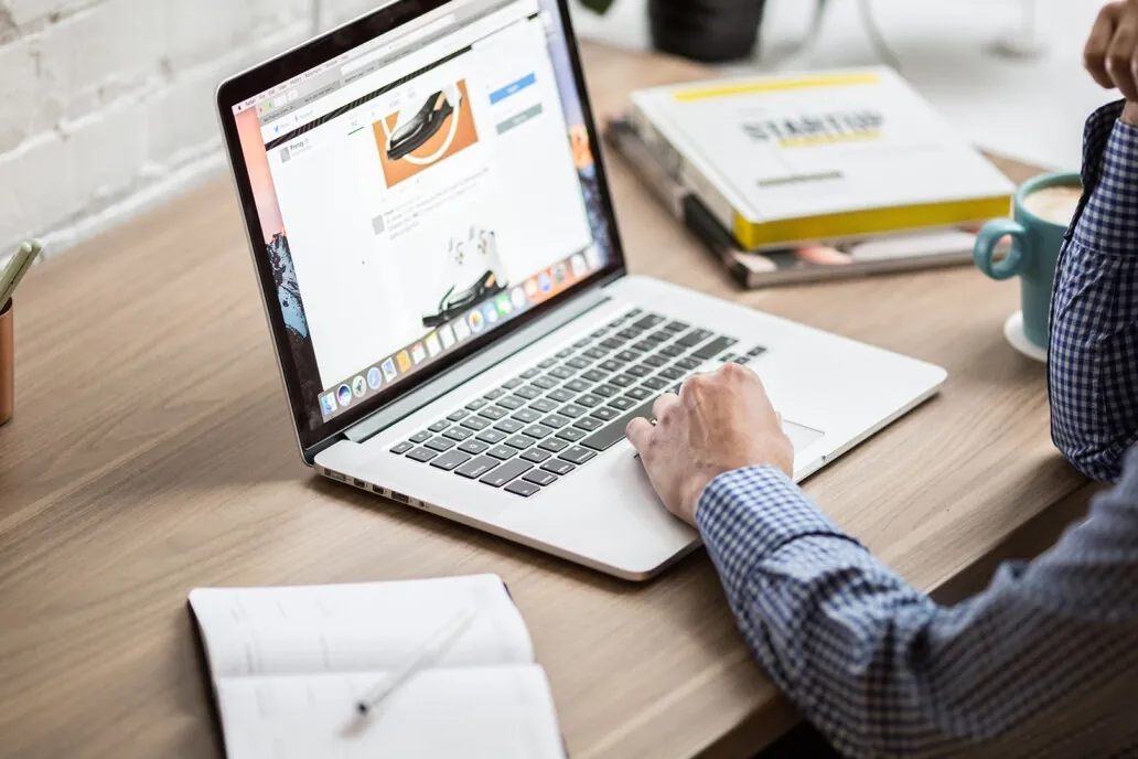 Person browsing a website on a laptop at a desk