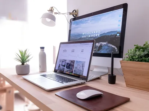 A laptop and monitor on a tidy desk showing website analytics